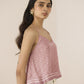 Woman wearing a pink floral top against a beige background Calling June