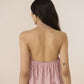 Woman wearing a pink halter top with a beige background Calling June