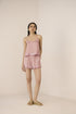 Woman wearing a pink checkered outfit on a beige background Calling June