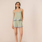 Woman wearing a light green patterned romper on a beige background Calling June