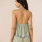 Woman wearing a green patterned romper with thin straps on a beige background Calling June