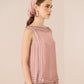 Woman wearing a pink patterned top and headscarf against a beige background Calling June