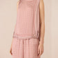 Woman wearing a pink patterned outfit on a beige background Calling June
