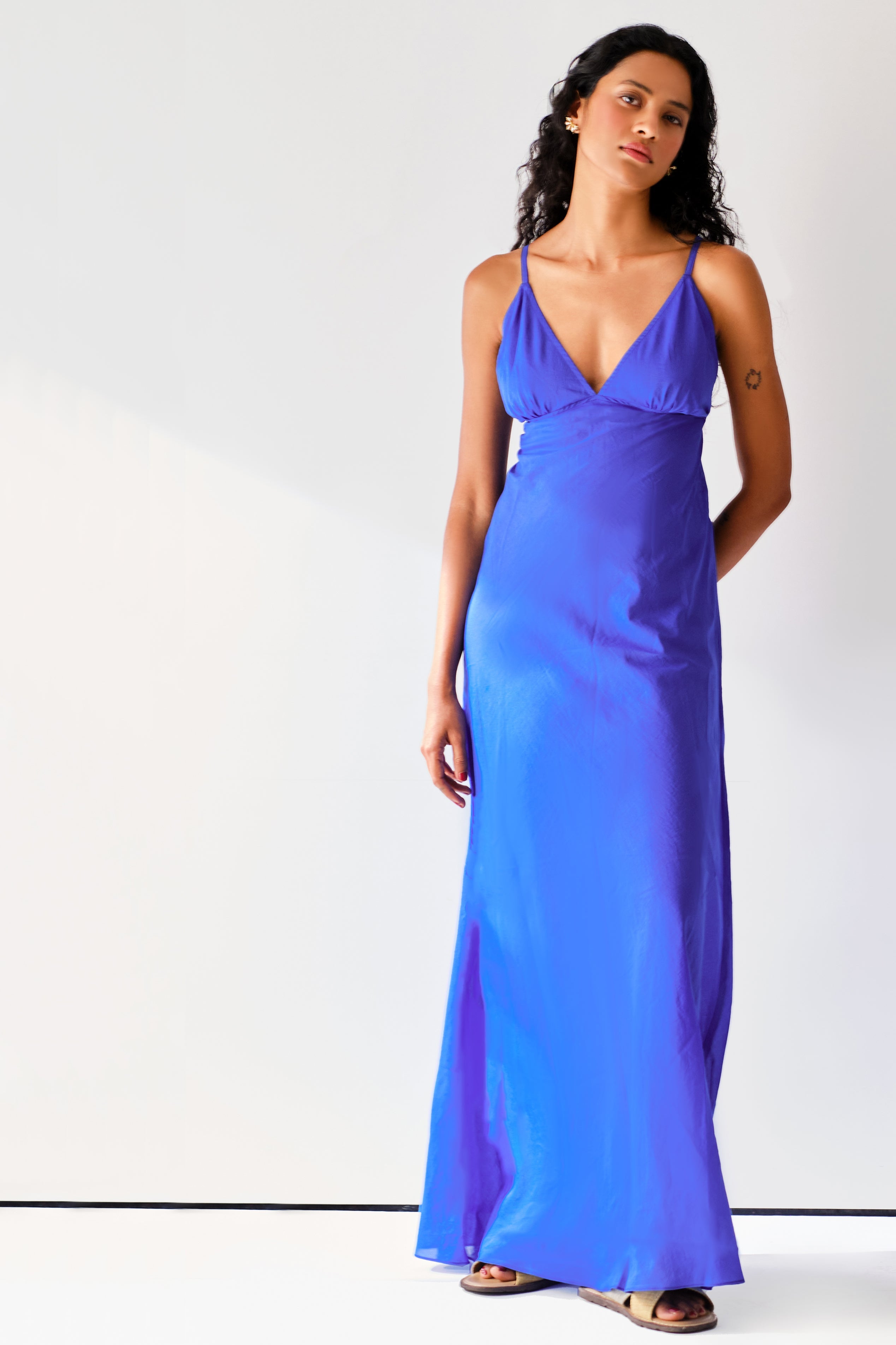 Made from lightweight silk-cotton, the Rhea slip has slim, adjustable straps and V shaped neckline. The dress cut on bias gently skims your frame before falling to a floor-length hem.